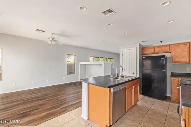 a kitchen with kitchen island granite countertop a sink and refrigerator