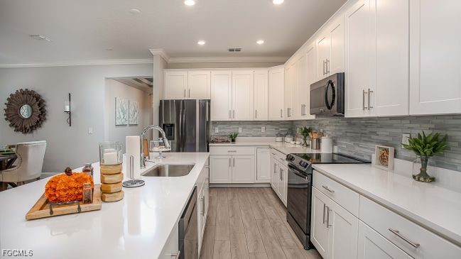 3508 14th Street Southwest Lehigh Acres, FL 33976 - Photo 5 of 23 a kitchen with white cabinets and stainless steel appliances