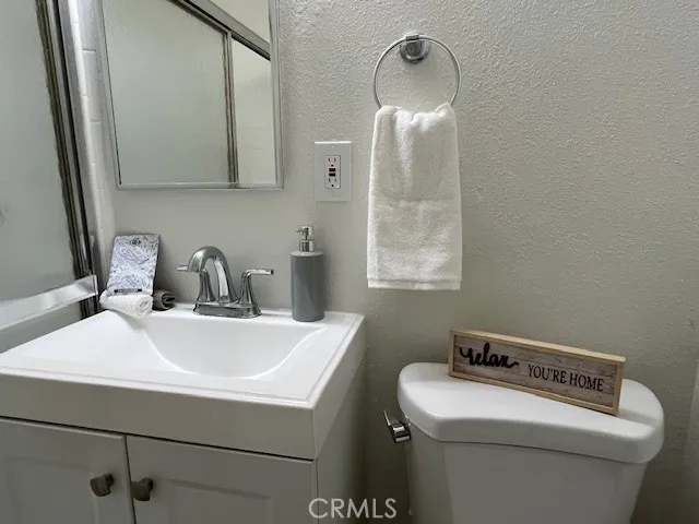 a bathroom with a sink a toilet and a mirror