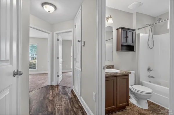 a bathroom with a granite countertop toilet a sink and shower