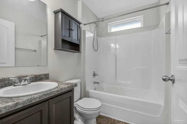 a bathroom with a granite countertop sink a toilet and shower