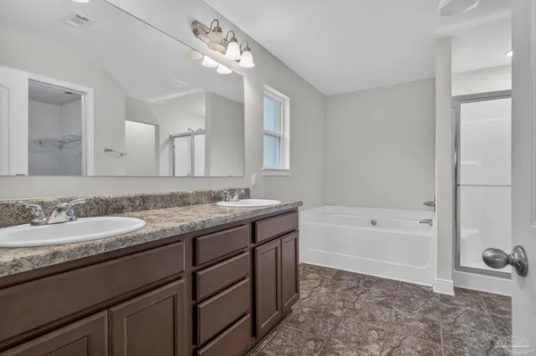 a spacious bathroom with a granite countertop sink a toilet mirror and bathtub