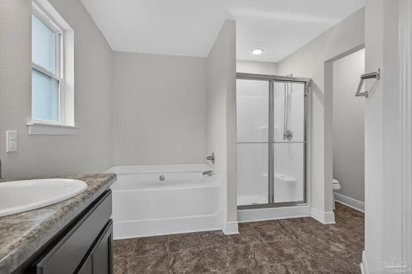 a bathroom with a granite countertop sink a toilet and shower