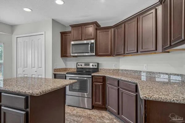 a kitchen with granite countertop stainless steel appliances and white cabinets