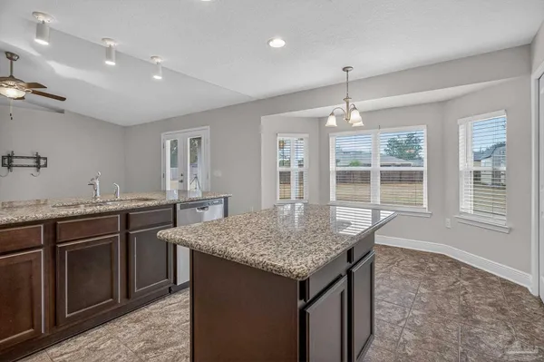 a kitchen with granite countertop stove sink and refrigerator