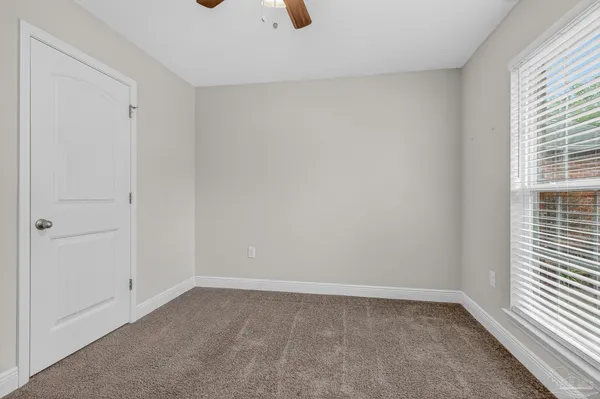 an empty room with closet and a window