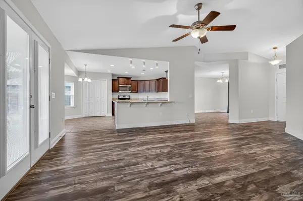 a view of empty room with wooden floor and ceiling fan