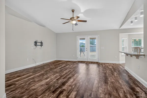 a view of empty room with wooden floor and ceiling fan