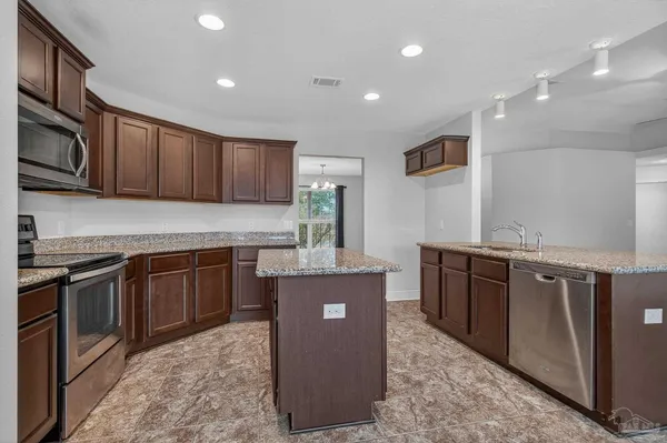 a kitchen with kitchen island granite countertop wooden cabinets a sink and dishwasher