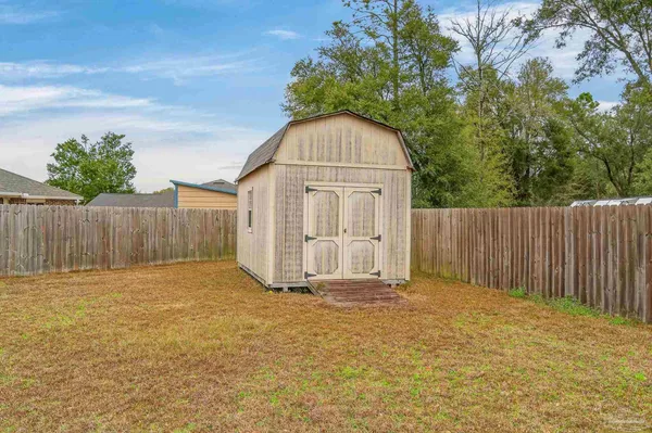 a view of backyard with wooden fence
