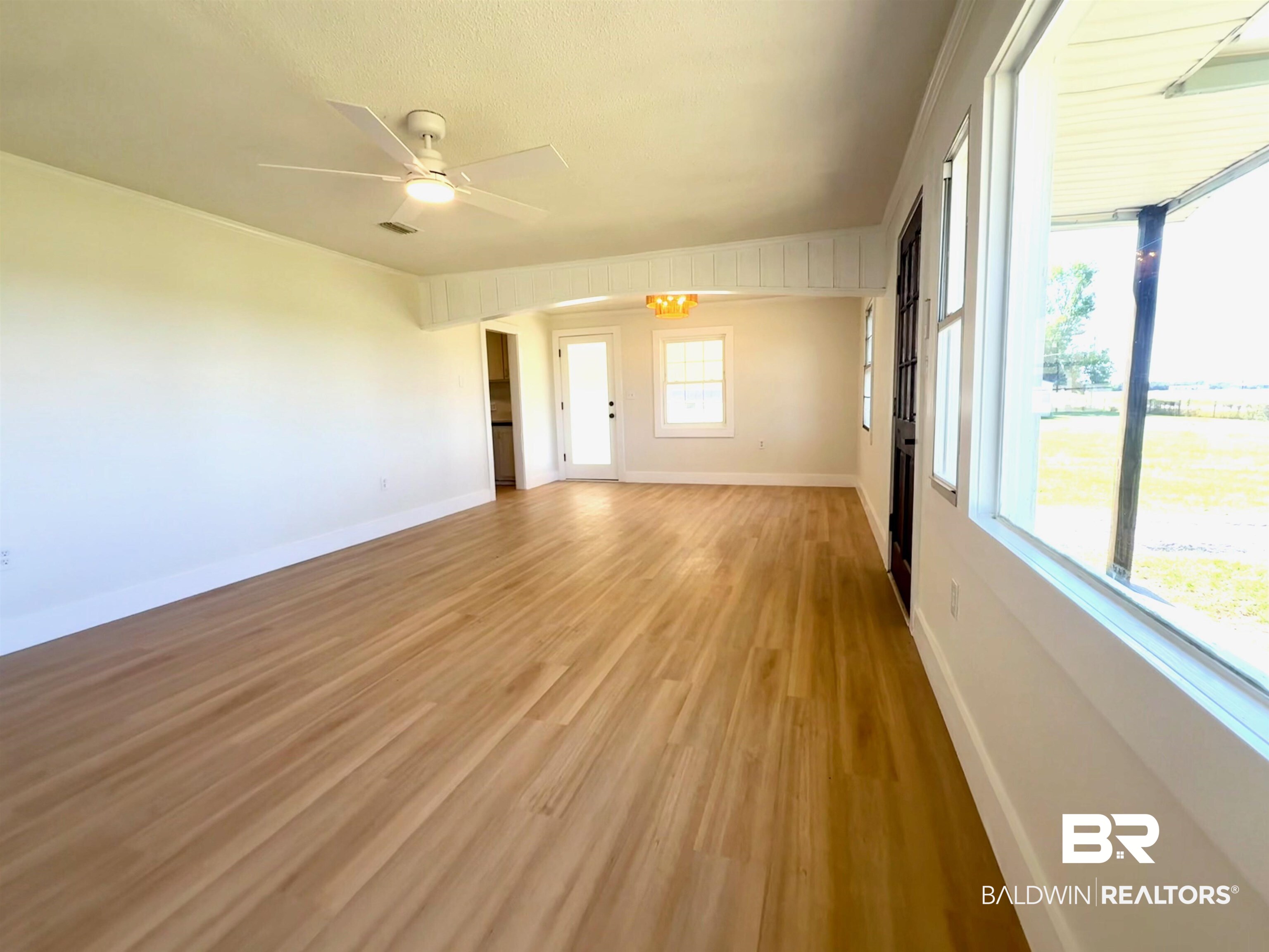 11698 Poser Road Foley, AL 36535 - Photo 19 of 20 Spare room featuring light wood-style floors, ornamental molding, a chandelier, and ceiling fan