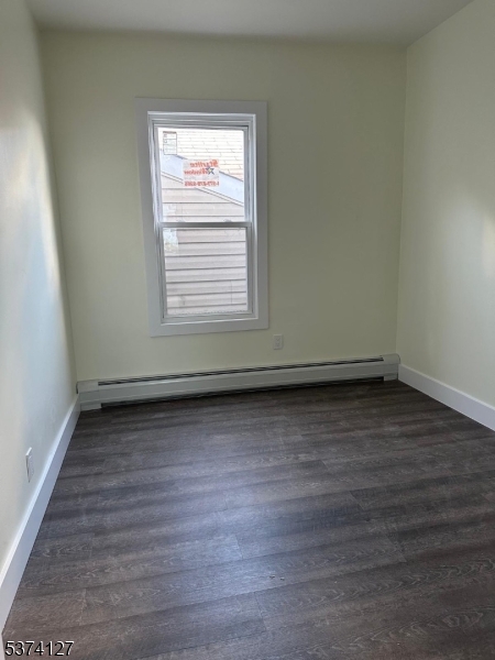 19 White Street Paterson, NJ 07522 - Photo 3 of 9 a view of an empty room with wooden floor and a window