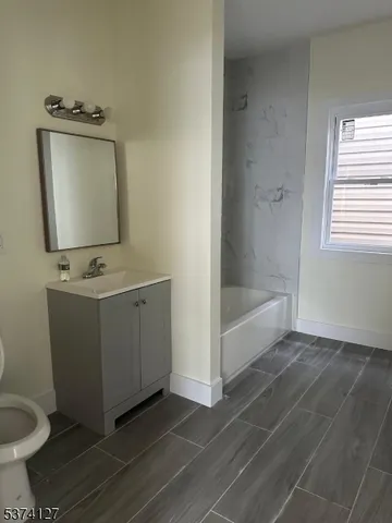 a bathroom with a toilet sink and mirror
