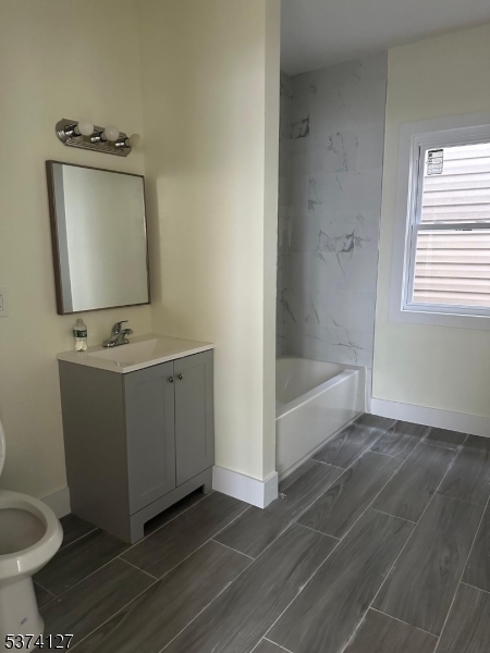 19 White Street Paterson, NJ 07522 - Photo 5 of 9 a bathroom with a toilet sink and mirror