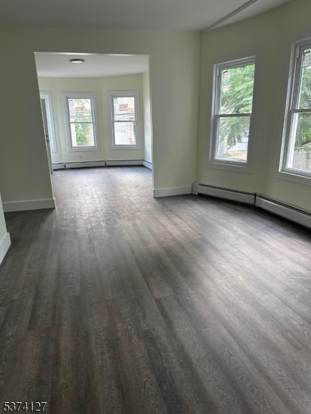 19 White Street Paterson, NJ 07522 - Photo 7 of 9 a view of an empty room with wooden floor and windows