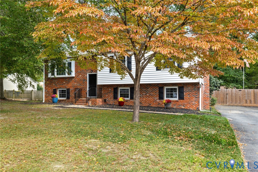 a front view of a house with a garden and trees