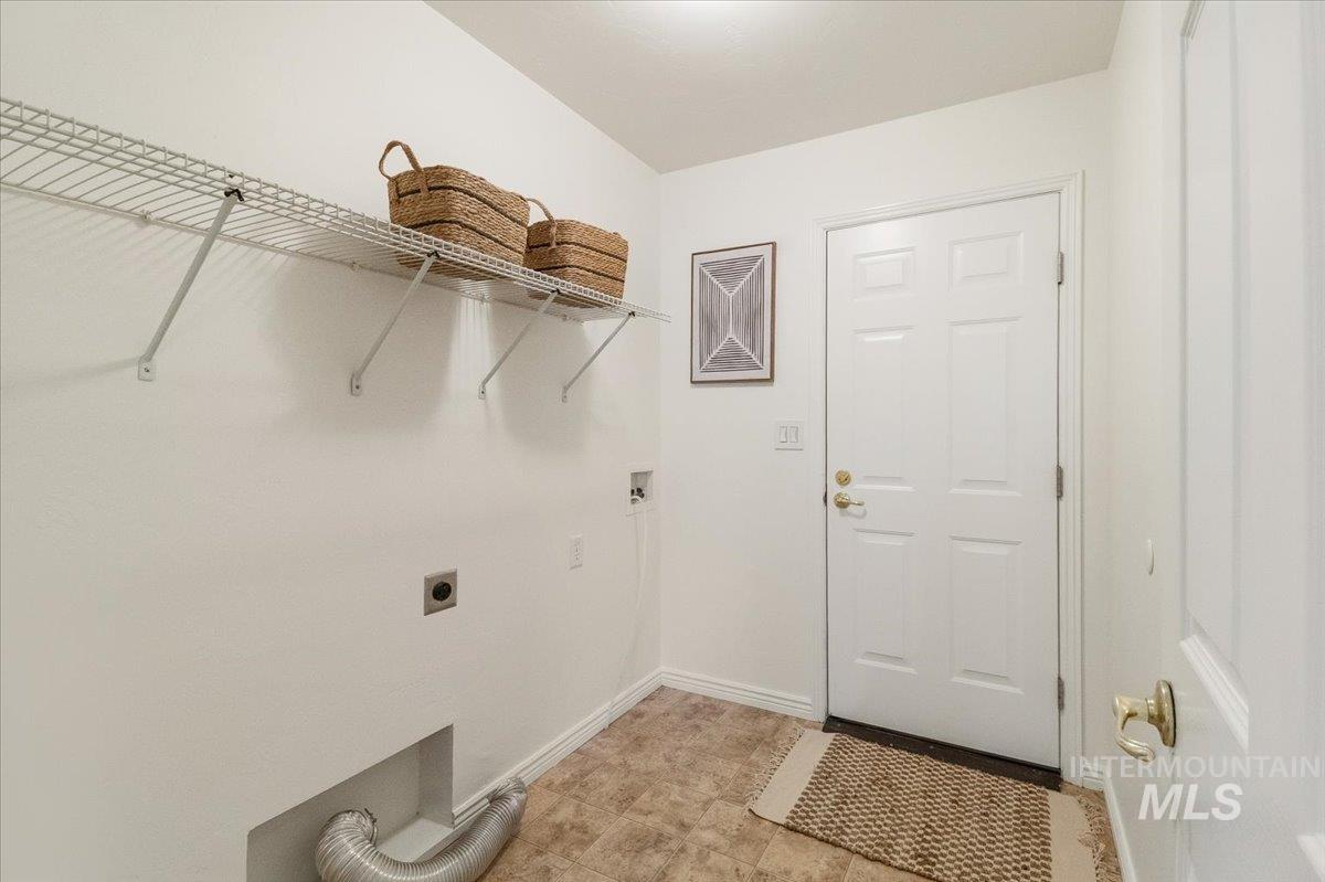 2032 Talus Loop Twin Falls, ID 83301 - Photo 28 of 43 Dedicated utility space featuring a wire shelving system, durable flooring, and a paneled entry door