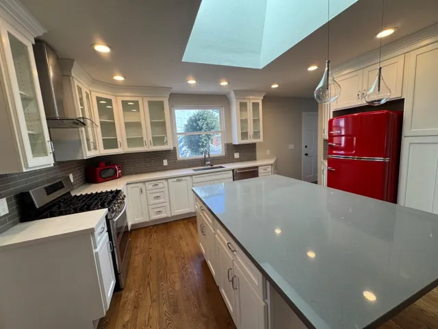 a kitchen with stainless steel appliances granite countertop a sink a stove and a refrigerator