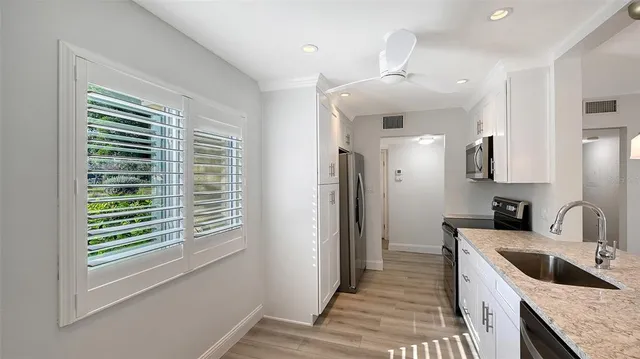 a kitchen with granite countertop a sink and a refrigerator