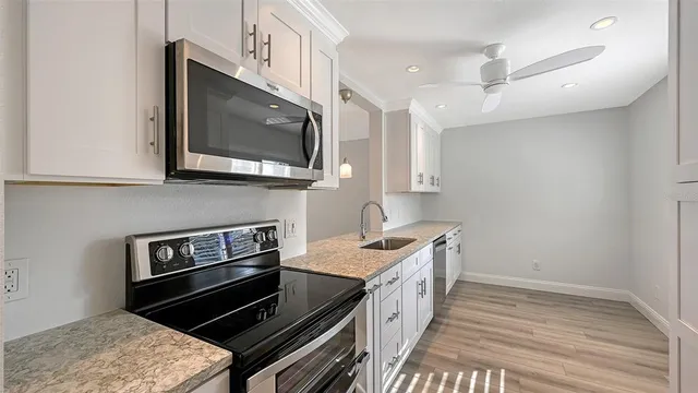 a kitchen with stainless steel appliances granite countertop a stove and a microwave