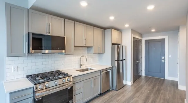 a kitchen with stainless steel appliances a refrigerator a sink and a stove