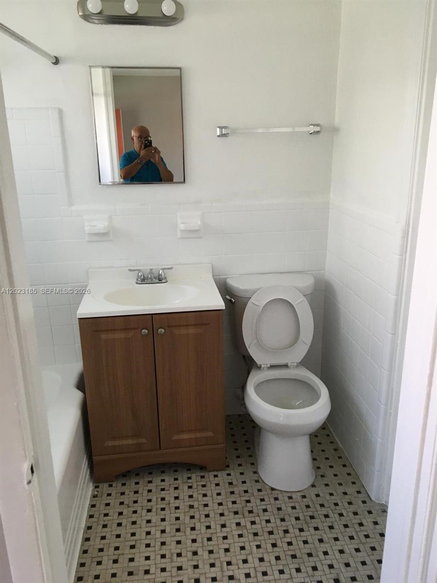 520 Southwest 4th Street, Unit 4 Miami, FL 33130 - Photo 8 of 12 a bathroom with a toilet a sink and mirror