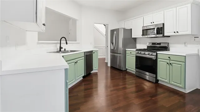 a kitchen with stainless steel appliances a refrigerator sink and microwave