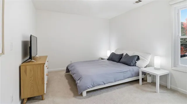 a bedroom with a bed tv and a chair