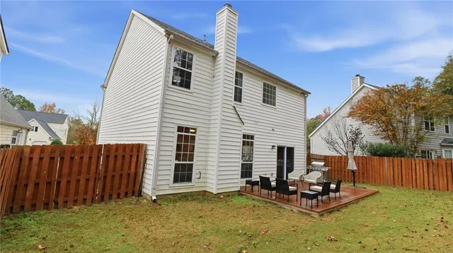 a backyard of a house with table and chairs