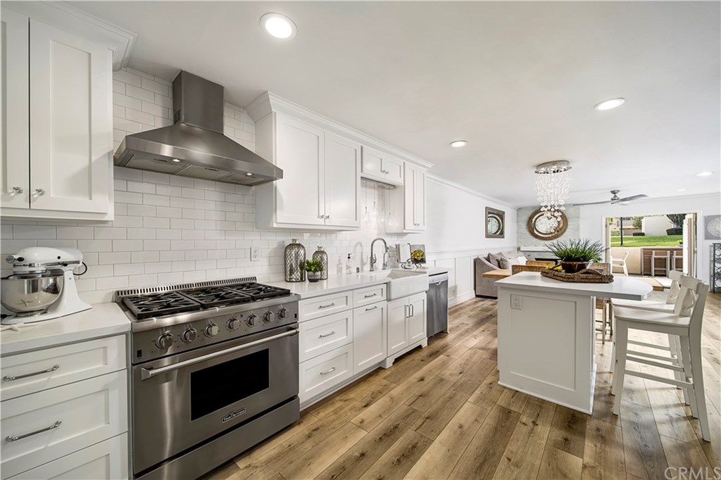 a kitchen with stainless steel appliances a stove a sink and cabinets