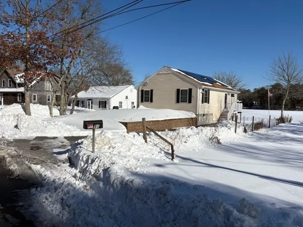 a view of a house with snow on the road