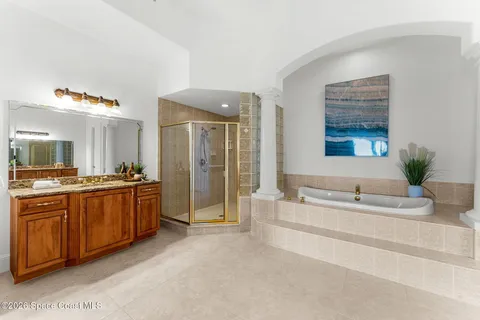 a spacious bathroom with a tub sink and mirror
