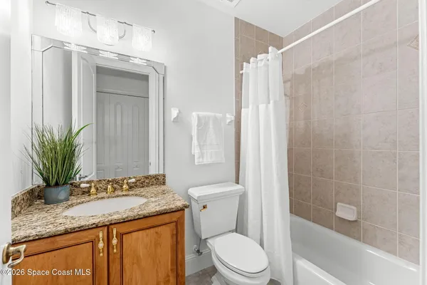 a bathroom with a granite countertop sink a toilet and shower