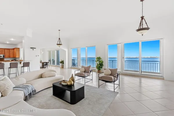 a living room with furniture a chandelier and a large window