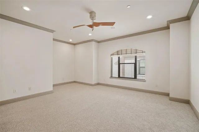 an empty room with a ceiling fan and window