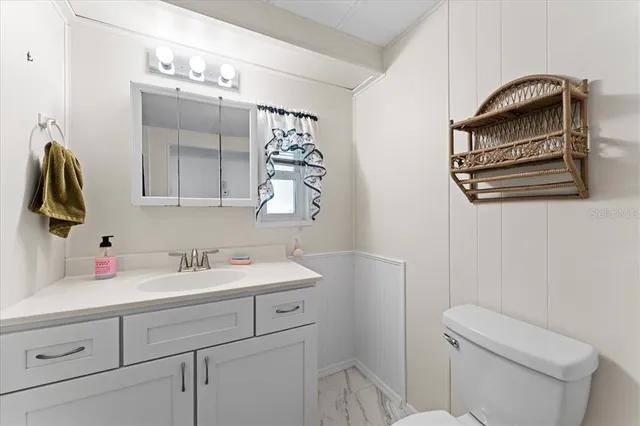 a bathroom with a sink a toilet and mirror