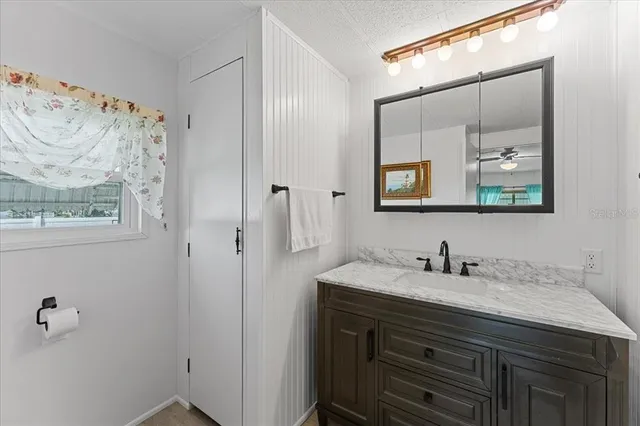 a bathroom with a sink vanity and mirror