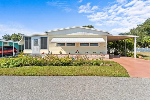 a front view of a house with a yard and potted plants