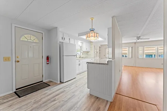 a view of a kitchen with wooden floor and electronic appliances