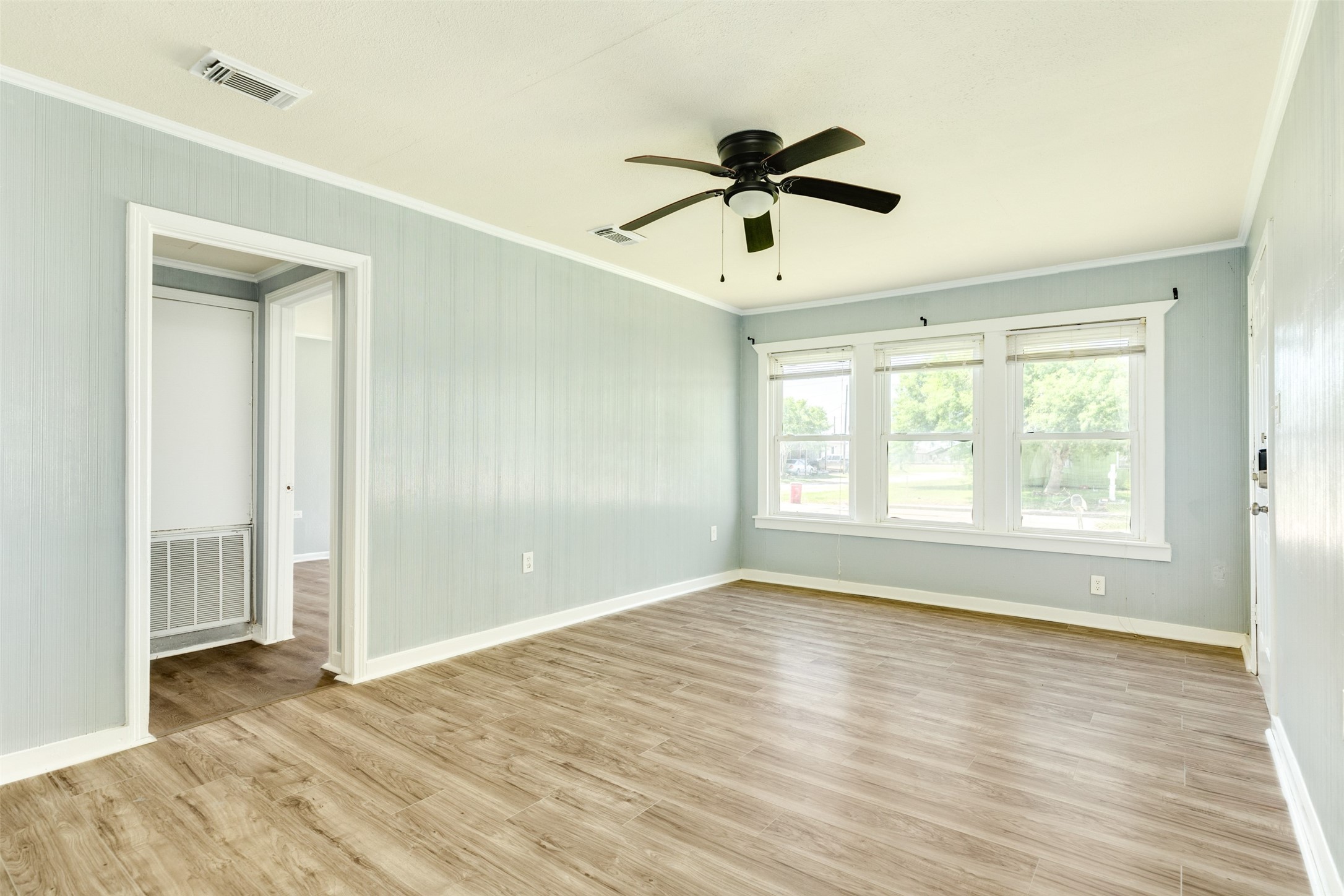 302 West 8th Street, Unit A Freeport, TX 77541 - Photo 4 of 25 a view of empty room with wooden floor and fan