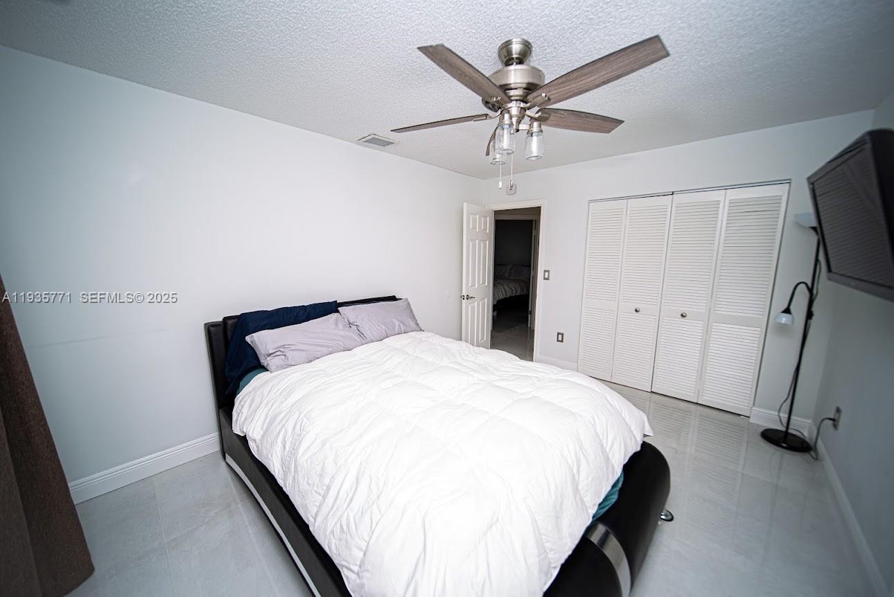 13020 Southwest 17th Court Miramar, FL 33027 - Photo 37 of 78 a bedroom with a large bed and a chandelier