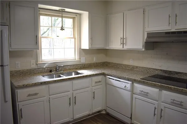 a kitchen with white cabinets and white appliances