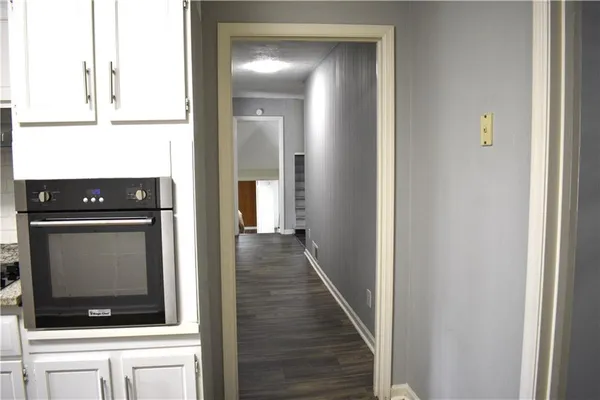 a view of a hallway with wooden floor and staircase