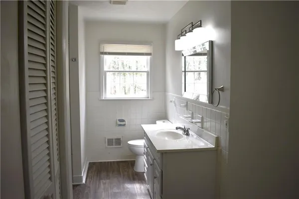 a bathroom with a sink a toilet and a window