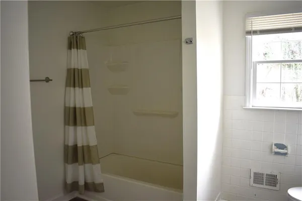 a bathroom with a shower and a window