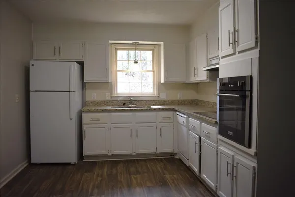 a kitchen with a refrigerator sink and cabinets