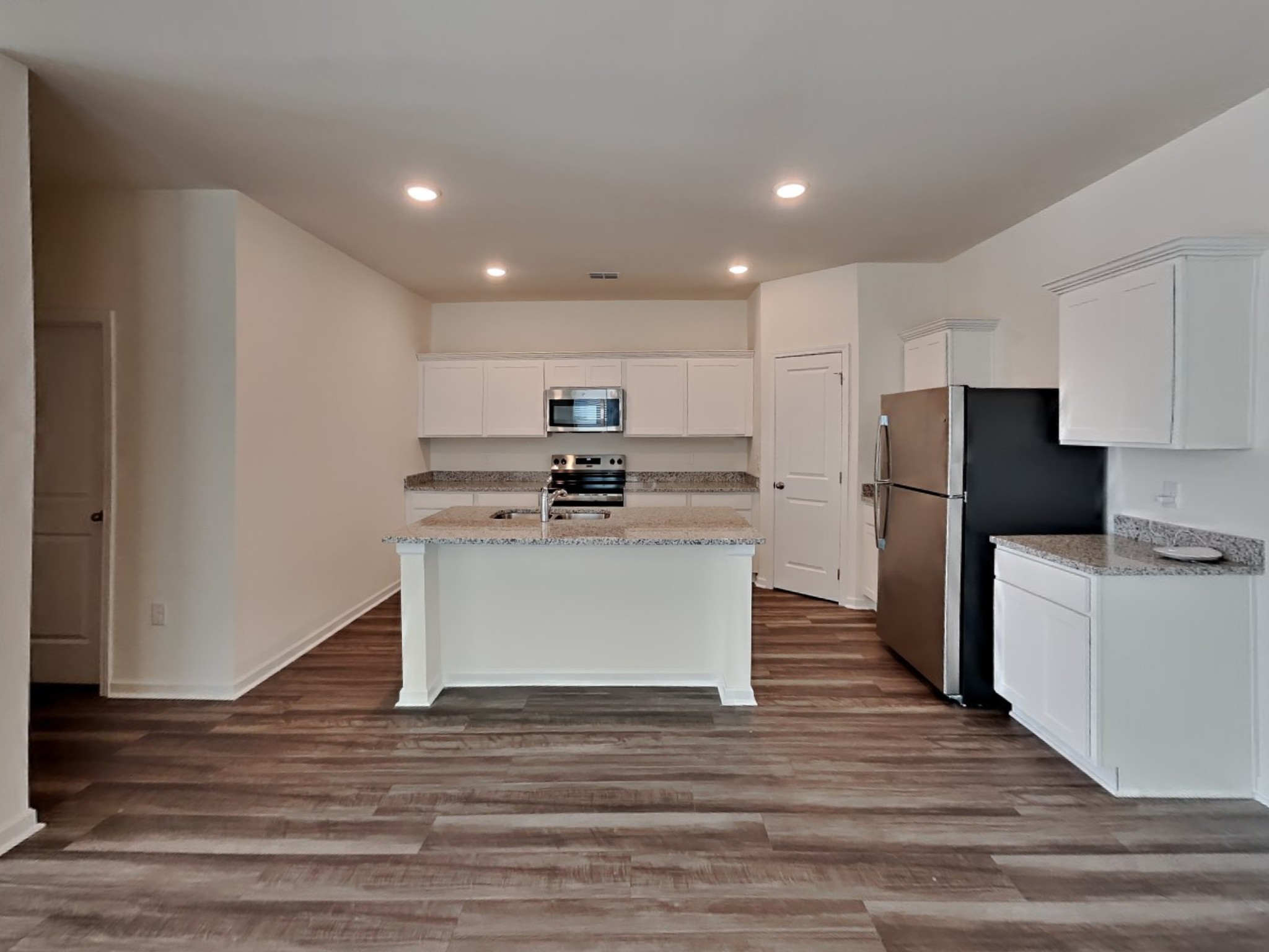 305 Nasturtium Way La Vergne, TN 37086 - Photo 4 of 22 a white kitchen with wooden floor and stainless steel appliances