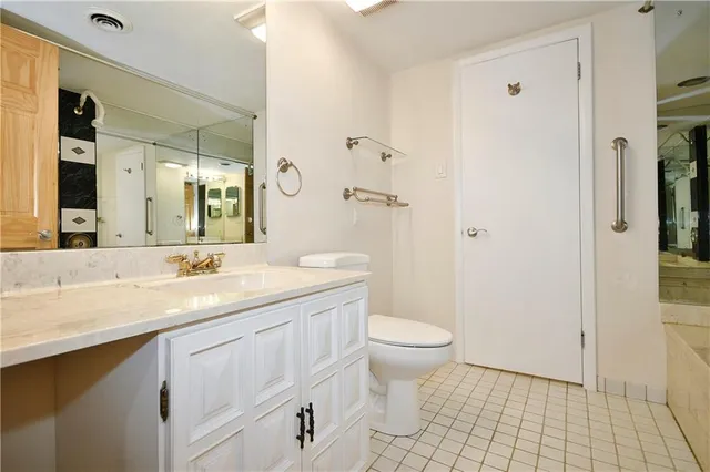 a bathroom with a granite countertop sink a toilet and a mirror