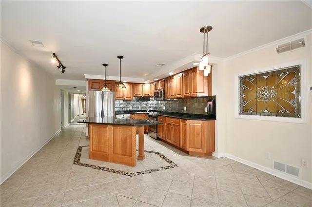 a kitchen with stainless steel appliances granite countertop a stove a sink and a refrigerator