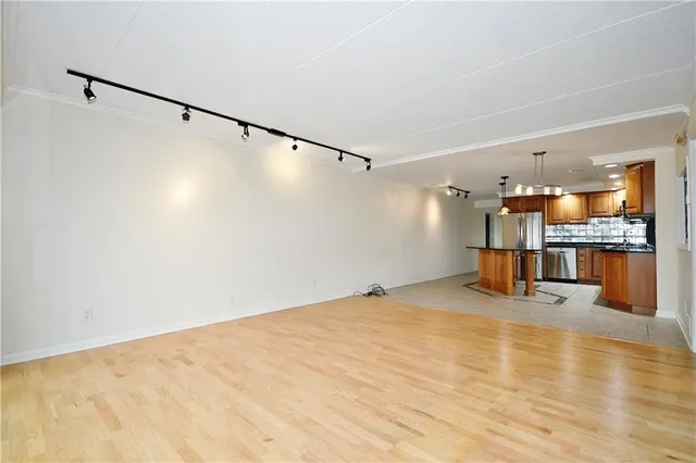 a view of empty room with wooden floor